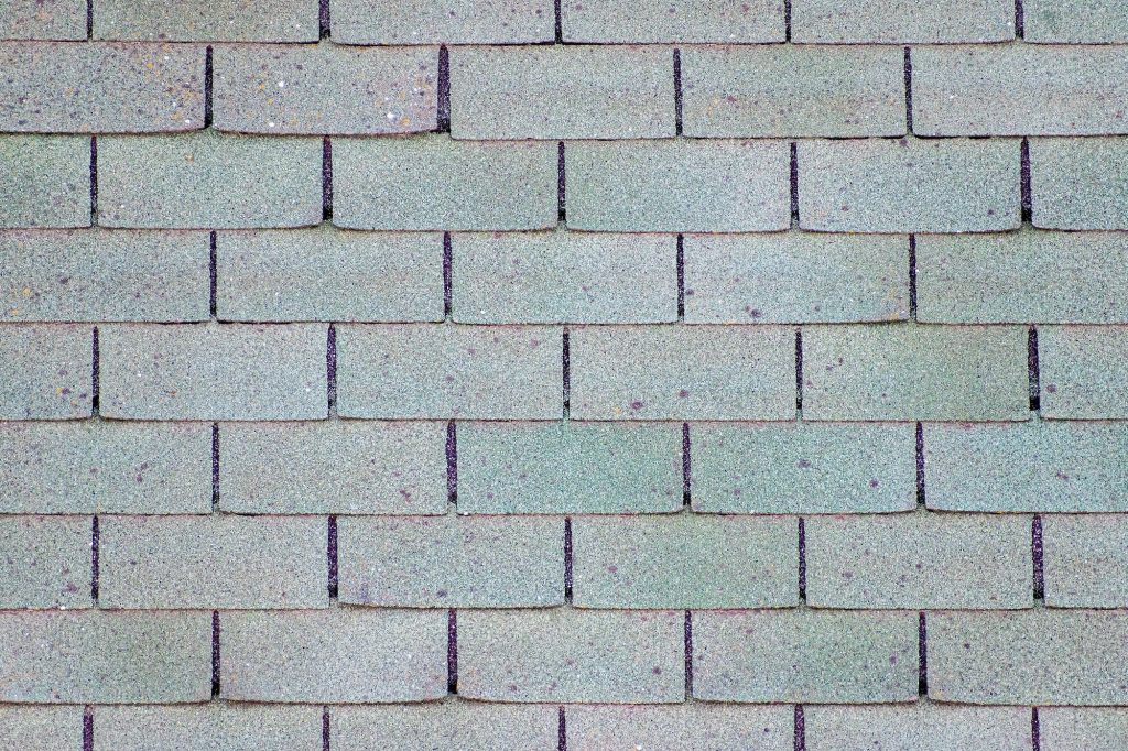 Surface of old worn asphalt shingles.